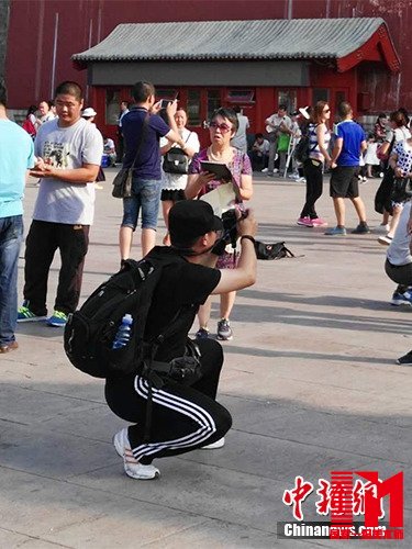 游客在故宫北门外拍照。中新网记者 宋宇晟 摄